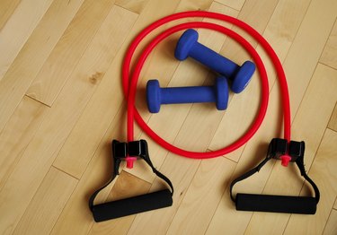 Red Resistance Band and Blue Weights on Gym Floor