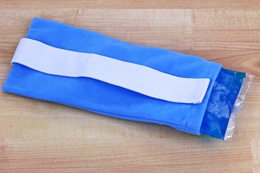 A blue reusable soft gel-filled cold and hot pack to relieve pain inside a fabric pouch