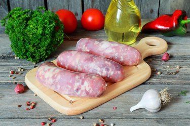 Raw meat sausages on a cutting board