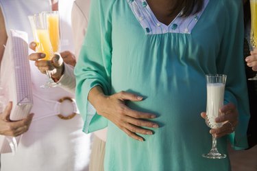 Pregnant Woman with Glass of Milk at a Baby Shower, Mid Section