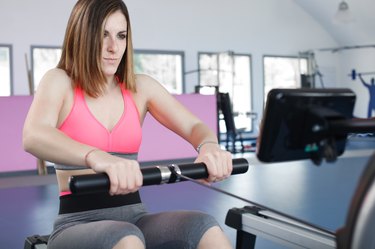 young woman exercising at the gym doing some pulls