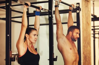 A man and woman about to do pull ups.
