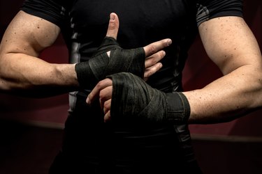 professional fighter preparing for training, wraping his hands and wrists