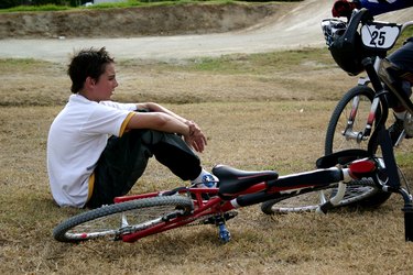 Boy sitting next to bmx bike