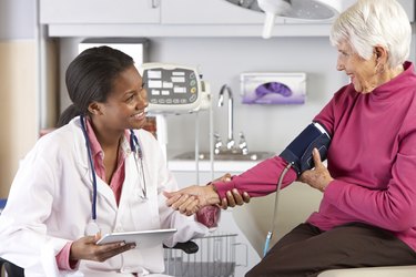 Doctor Taking Senior Female Patient's Blood Pressure