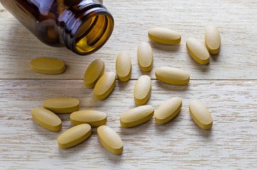 Pills of vitamin C spilled out open container