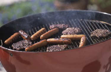 烹调在烤肉格栅的汉堡包和热狗特写镜头