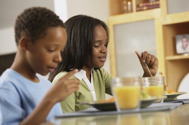 African brother and sister eating breakfast