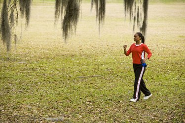 Young woman in sports clothing jogging on ground