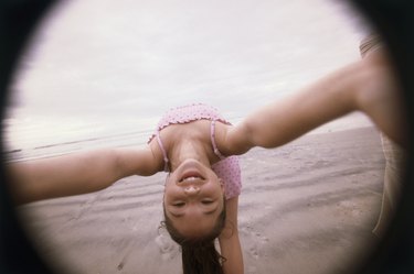 Girl bending over backwards on the beach