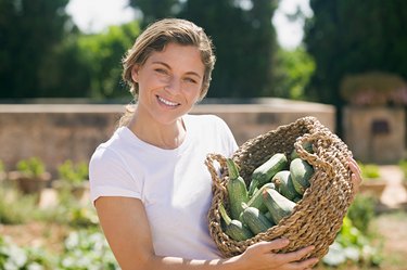 Woman holding a basket of courgettes