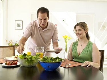 Couple smiling and eating a salad
