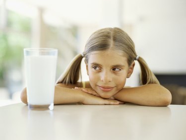 Close-up of a girl looking at a  glass of milk