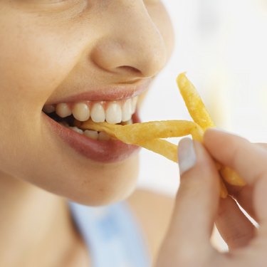Close-up of a woman eating fries