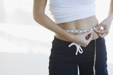 Woman measuring waistline