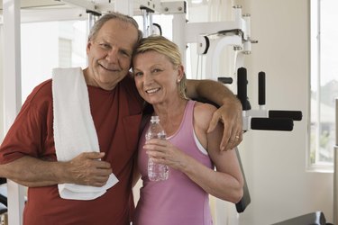 Smiling couple embracing in home gym