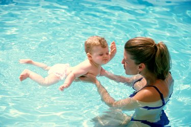 High angle view of a mother teaching her son to swim