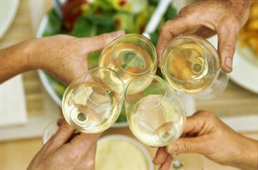 Elevated view of four glasses of white wine held together