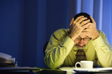 Hispanic businessman with head in hands