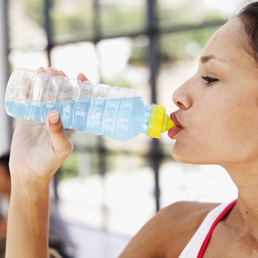 Side profile of a woman drinking water from a bottle