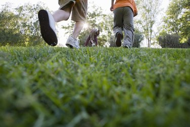 a group of young boys walking across grass