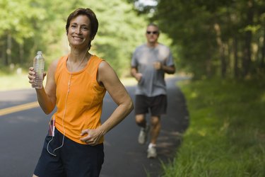 Smiling jogger with bottle of water