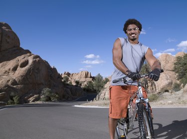 African man standing on mountain bike