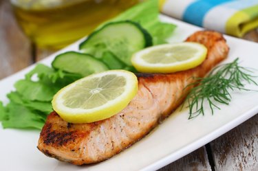 Grilled salmon with slices of lemon and green side salad