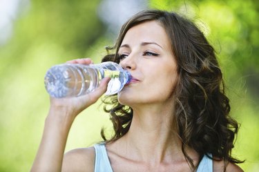 young dark-haired woman drinking water