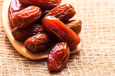 dried dates on wooden spoon cloth background