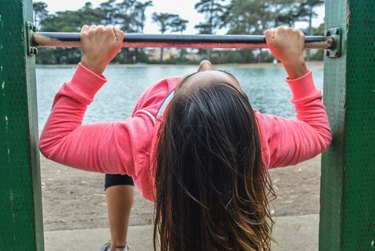 Athletic skinny woman doing pull up rows