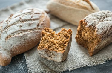 Whole grain breads on the dark wooden background