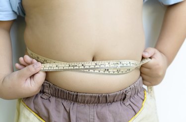 Fat boy measuring his belly