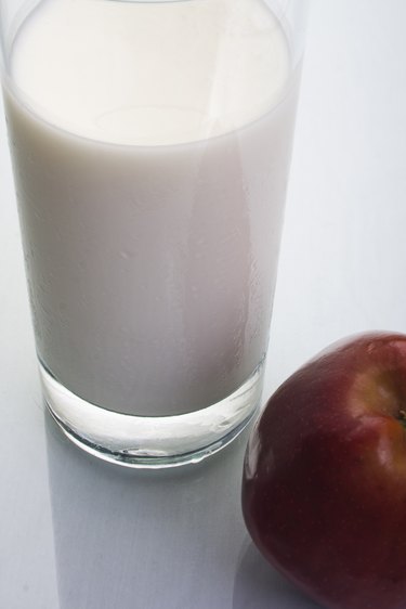 Glass of milk with an apple, studio shot