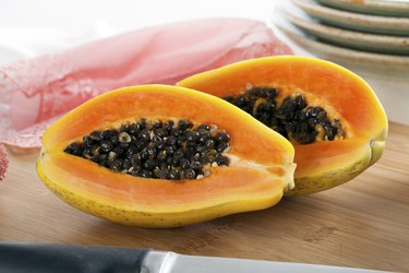 Sliced papaya on wooden cutting board can be used as a bleaching or skin-whitening soap for a papaya soap whitening before and after