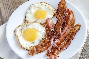 Fried eggs with bacon on the wooden table