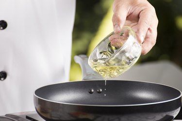 Chef pouring vegetable oil to the pan