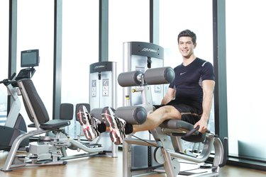 man exercising on leg extension machine