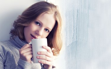 beautiful dreamy young woman with a cup of hot coffee