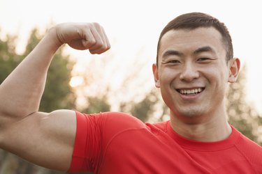 A muscular man is flexing his bicep