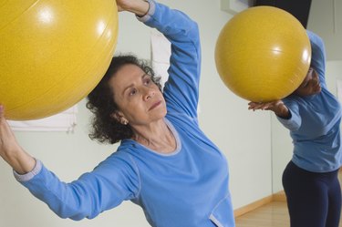 Senior Woman Using Exercise Ball in Fitness Class