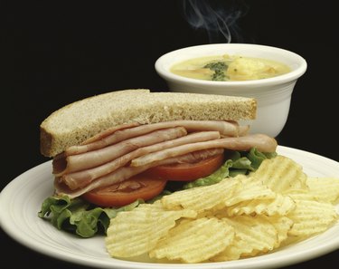 Ham sandwich with potato chips and soup