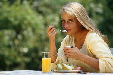 Young woman eating breakfast outdoors