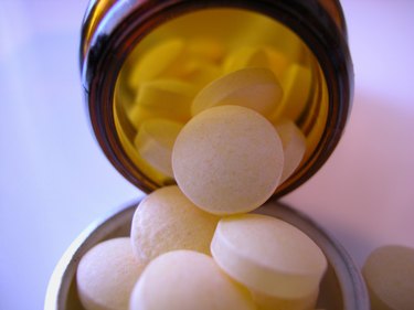 close up of probiotic supplements spilling out of a glass bottle