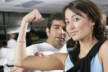 Portrait of a young man measuring a young woman's bicep