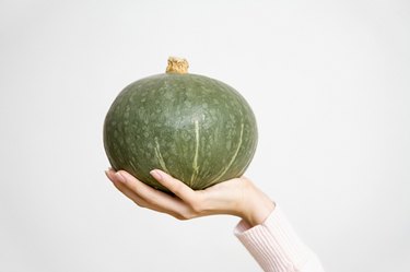 Person holding a kabocha pumpkin
