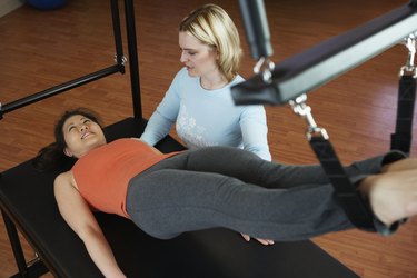 Asian woman exercising with personal trainer