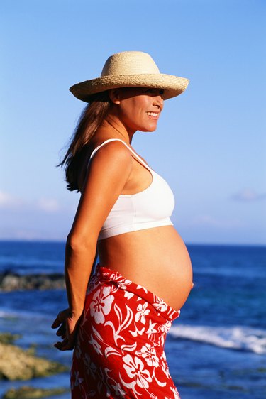 Pregnant woman standing near coast