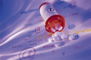 White tablets and prescription bottle with internet symbols