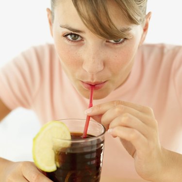 portrait of a young woman drinking cola from a straw